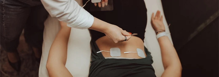 Doctor preforming Electrical Muscle Stimulation to a patients back