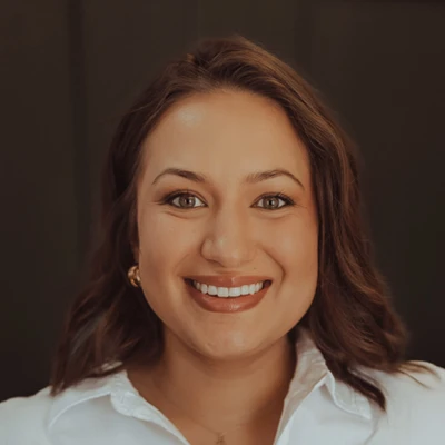 Doctor Sierra Marquez-Mazour headshot, she is smiling in a white shirt