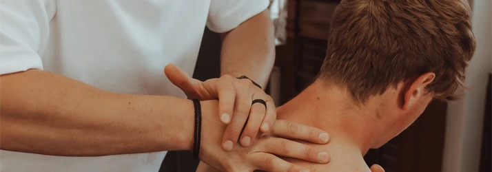 Chiropractor Lincoln NE Tanner Mazour Chiropractic Care Dr. Tanner Mazour adjusting the back of a patient neck
