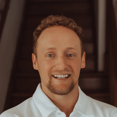 Doctor Tanner Mazour headshot, he is smiling in a white shirt